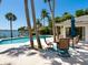 Beautiful backyard pool surrounded by lush palm trees overlooking the water at 7614 Peninsular Dr, Sarasota, FL 34231