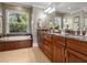 Bathroom featuring a jacuzzi tub, wood cabinetry and granite countertops at 7614 Peninsular Dr, Sarasota, FL 34231