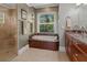 Bathroom with step-up tub, granite countertop, and a glass door shower at 7614 Peninsular Dr, Sarasota, FL 34231