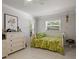 Bright bedroom features a bed with tropical-themed bedding and two windows at 7614 Peninsular Dr, Sarasota, FL 34231