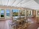 Dining area boasting water views, tile floors, natural light, a decorative chandelier, and seating for six at 7614 Peninsular Dr, Sarasota, FL 34231