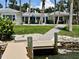 A waterfront home with a dock and outdoor seating area, surrounded by lush landscaping and a tranquil view at 7614 Peninsular Dr, Sarasota, FL 34231