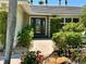 Charming front entrance with a brick walkway, decorative plants, and an inviting glass door at 7614 Peninsular Dr, Sarasota, FL 34231