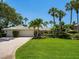 Beautifully landscaped home with a circular driveway, lush lawn, and well-maintained facade at 7614 Peninsular Dr, Sarasota, FL 34231
