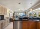 Open floor plan: stainless steel dishwasher and wine cooler, island with granite countertop, and a view to the living room at 7614 Peninsular Dr, Sarasota, FL 34231