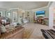 Bright living room with tile floors, a large TV, neutral paint and comfortable seating with a glass coffee table at 7614 Peninsular Dr, Sarasota, FL 34231