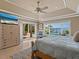 Spacious bedroom with tray ceiling, ceiling fan, water view, pool access and television at 7614 Peninsular Dr, Sarasota, FL 34231