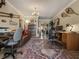 Bright home office with a chandelier, unique decorations and large rug at 7614 Peninsular Dr, Sarasota, FL 34231
