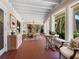 Sun room boasting tile floors, natural light and seating with views of the landscaping around the home at 7614 Peninsular Dr, Sarasota, FL 34231