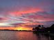 Striking sunset with colorful clouds reflecting on the water, and scenic waterfront views at 7614 Peninsular Dr, Sarasota, FL 34231