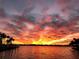 Gorgeous sunset view over a tranquil body of water, with palm trees lining the shore at 7614 Peninsular Dr, Sarasota, FL 34231