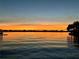 Scenic sunset over still waters, with an orange horizon creating a peaceful and picturesque scene at 7614 Peninsular Dr, Sarasota, FL 34231