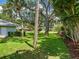 Lush green yard features mature trees, tropical foliage and ample shade creating a serene outdoor space at 7614 Peninsular Dr, Sarasota, FL 34231