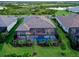 Aerial view of a house with a screened-in patio, swimming pool, and lush green backyard, in a community with lakes at 7838 Bowspirit Way, Lakewood Ranch, FL 34202
