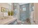 Modern bathroom features a walk-in shower with blue tile, white countertops, and decorative wall art at 7838 Bowspirit Way, Lakewood Ranch, FL 34202