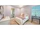 Charming pink themed bedroom with a full bed, decorative artwork, and a view into the en suite bathroom at 7838 Bowspirit Way, Lakewood Ranch, FL 34202