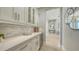Butler's pantry features custom white cabinets, wine fridge, and a decorative backsplash with a view to the foyer at 7838 Bowspirit Way, Lakewood Ranch, FL 34202