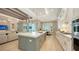 Modern kitchen with large island, white countertops, and stainless steel appliances opening to living and dining areas at 7838 Bowspirit Way, Lakewood Ranch, FL 34202