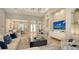Bright living room featuring modern furnishings, light hardwood floors, and large-screen television at 7838 Bowspirit Way, Lakewood Ranch, FL 34202