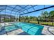 Sparkling pool and spa with lounge chairs, set within a screened enclosure, and lush tropical landscaping at 7838 Bowspirit Way, Lakewood Ranch, FL 34202