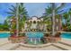 Beautiful community pool with palm trees, lounge chairs, fountain, and elegant building backdrop at 7838 Bowspirit Way, Lakewood Ranch, FL 34202