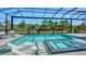 Sparkling pool and spa with lounge chairs, set within a screened enclosure, and lush tropical landscaping at 7838 Bowspirit Way, Lakewood Ranch, FL 34202