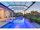 Enjoy the evening in your pool and spa with colored lights and tropical landscaping behind the screened enclosure at 7838 Bowspirit Way, Lakewood Ranch, FL 34202