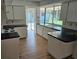 Well-lit kitchen featuring wood floors and a large sink with backyard view at 8040 Canterbury Cir, Seminole, FL 33777