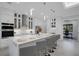 Modern kitchen with white cabinets, stone counters, stainless steel appliances, and eat in island at 805 Padua Ct, Nokomis, FL 34275
