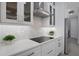 Modern kitchen with white cabinets, stainless steel appliances, and eye-catching backsplash at 805 Padua Ct, Nokomis, FL 34275