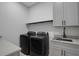 Well-equipped laundry room with modern washer and dryer, sink, and ample counter space at 805 Padua Ct, Nokomis, FL 34275