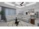 Open-concept living space with neutral sectional sofa and view into modern kitchen with island seating at 805 Padua Ct, Nokomis, FL 34275