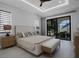 Serene main bedroom with neutral tones, tray ceiling, and sliding glass door to the patio at 805 Padua Ct, Nokomis, FL 34275