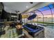 Captivating outdoor living space featuring a fire pit, summer kitchen, and screened-in pool area at 805 Padua Ct, Nokomis, FL 34275
