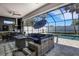 Relaxing outdoor living area with a lounge area and summer kitchen overlooking the screened-in pool at 805 Padua Ct, Nokomis, FL 34275