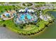 An aerial view showcases a community pool with lounging area, playground and green spaces by a lake at 8940 Royal River Cir, Parrish, FL 34219