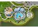 Aerial view showcases a pool, playground, landscaping and green space within a lakeside community at 8940 Royal River Cir, Parrish, FL 34219