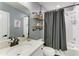 Bathroom with a modern sink, decoratively adorned shelving, and a shower with white subway tiles and a black shower curtain at 8940 Royal River Cir, Parrish, FL 34219