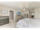 Bedroom featuring dresser, TV and adjacent bathroom with tile floors at 8940 Royal River Cir, Parrish, FL 34219