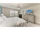 Bright bedroom with shuttered windows, ceiling fan, dresser, and TV at 8940 Royal River Cir, Parrish, FL 34219