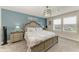 Bedroom featuring a blue accent wall, large windows, and decorative lighting fixture at 8940 Royal River Cir, Parrish, FL 34219