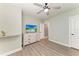 Bedroom featuring stylish décor, a ceiling fan, woodgrain vinyl flooring, natural light, and a TV above a dresser at 8940 Royal River Cir, Parrish, FL 34219