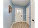 Bright entryway featuring light blue walls, a white front door with glass, and wood-look flooring at 8940 Royal River Cir, Parrish, FL 34219