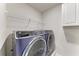 Modern laundry room features front load washer and dryer set with a metal shelf for additional storage at 8940 Royal River Cir, Parrish, FL 34219
