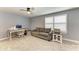 Living room featuring neutral carpet, a ceiling fan, a sofa, and an office area at 8940 Royal River Cir, Parrish, FL 34219