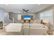 Comfortable living room with gray couches, entertainment center, ceiling fan, and stairway at 8940 Royal River Cir, Parrish, FL 34219