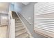 Carpeted staircase with white railing and a view of the front door and window shutters at 8940 Royal River Cir, Parrish, FL 34219