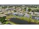 Aerial view of several homes featuring screen enclosed pools, manicured lawns, canals, and golf course views at 965 E Gondola Dr, Venice, FL 34293