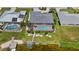 Aerial view of backyard featuring screen enclosed pool, manicured lawn, tropical plants, and dock with boat lift at 965 E Gondola Dr, Venice, FL 34293