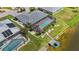 Aerial view of backyard featuring screen enclosed pool, manicured lawn, tropical plants, and dock with boat lift at 965 E Gondola Dr, Venice, FL 34293
